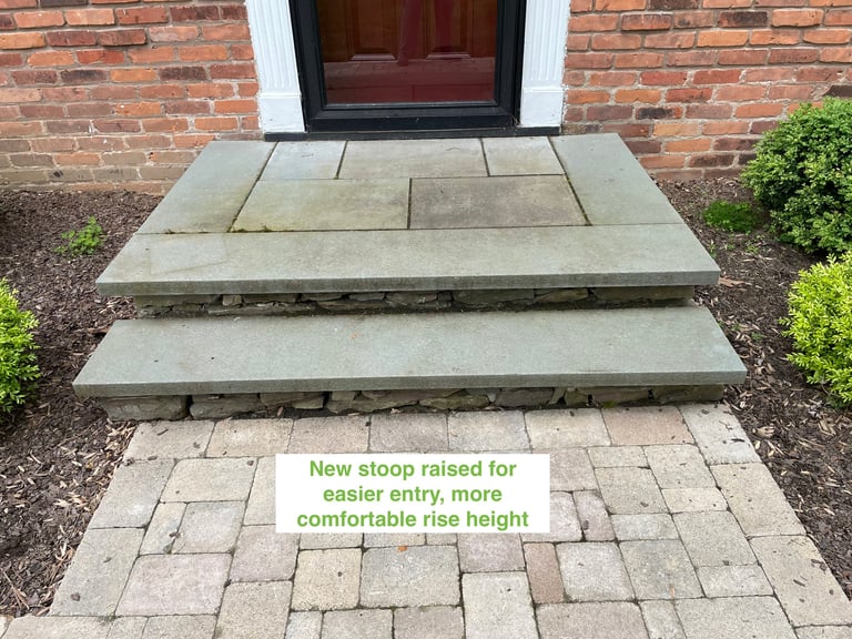 New raised concrete stoop with steps at brick home entrance, labeled for easier entry with comfortable rise height